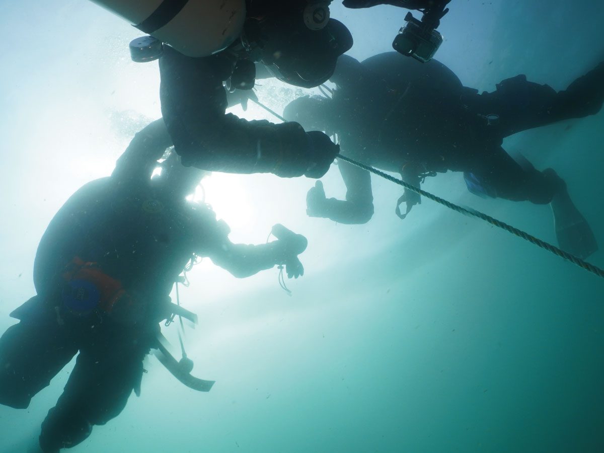 Dive pro with divers on a shot line