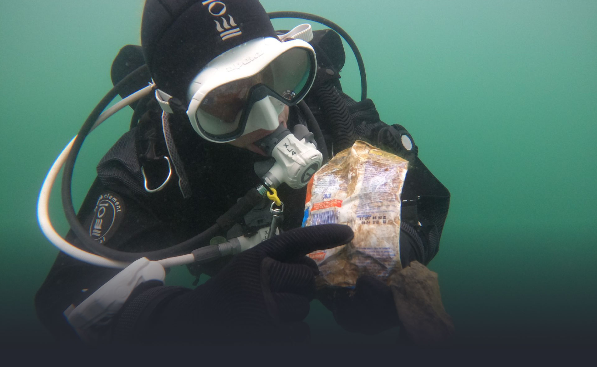 A diver removing litter from the ocean during marine biology dive training