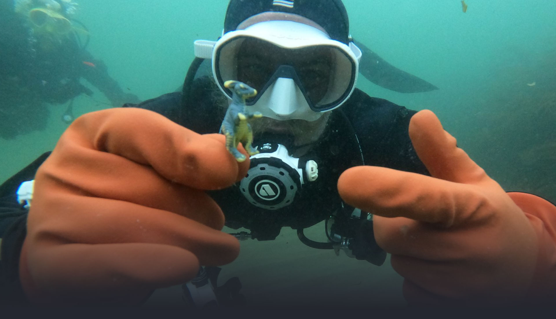 James, our co-founder, holding a toy dinosaur found when eco-diving with The Fifth Point