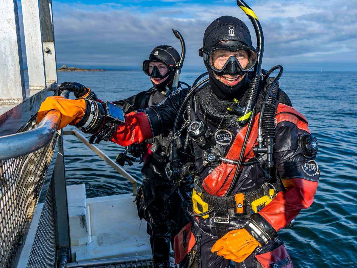 Dry suit divers on a boat lift